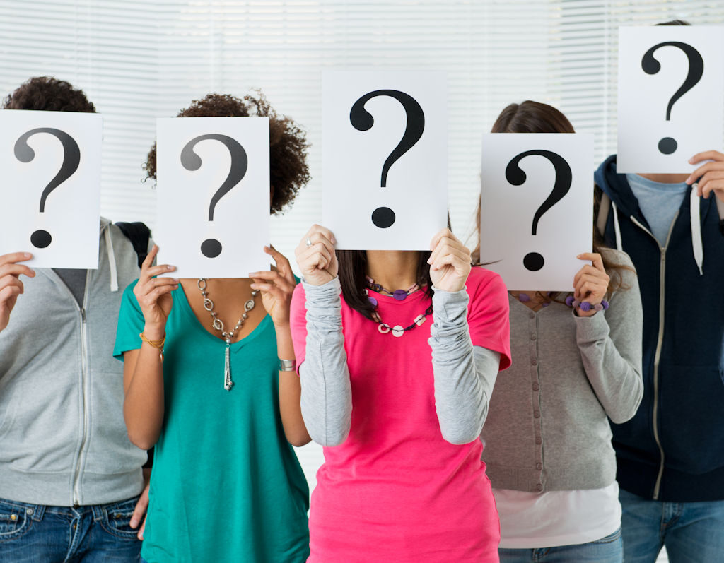 Five people holding question mark signs over their faces